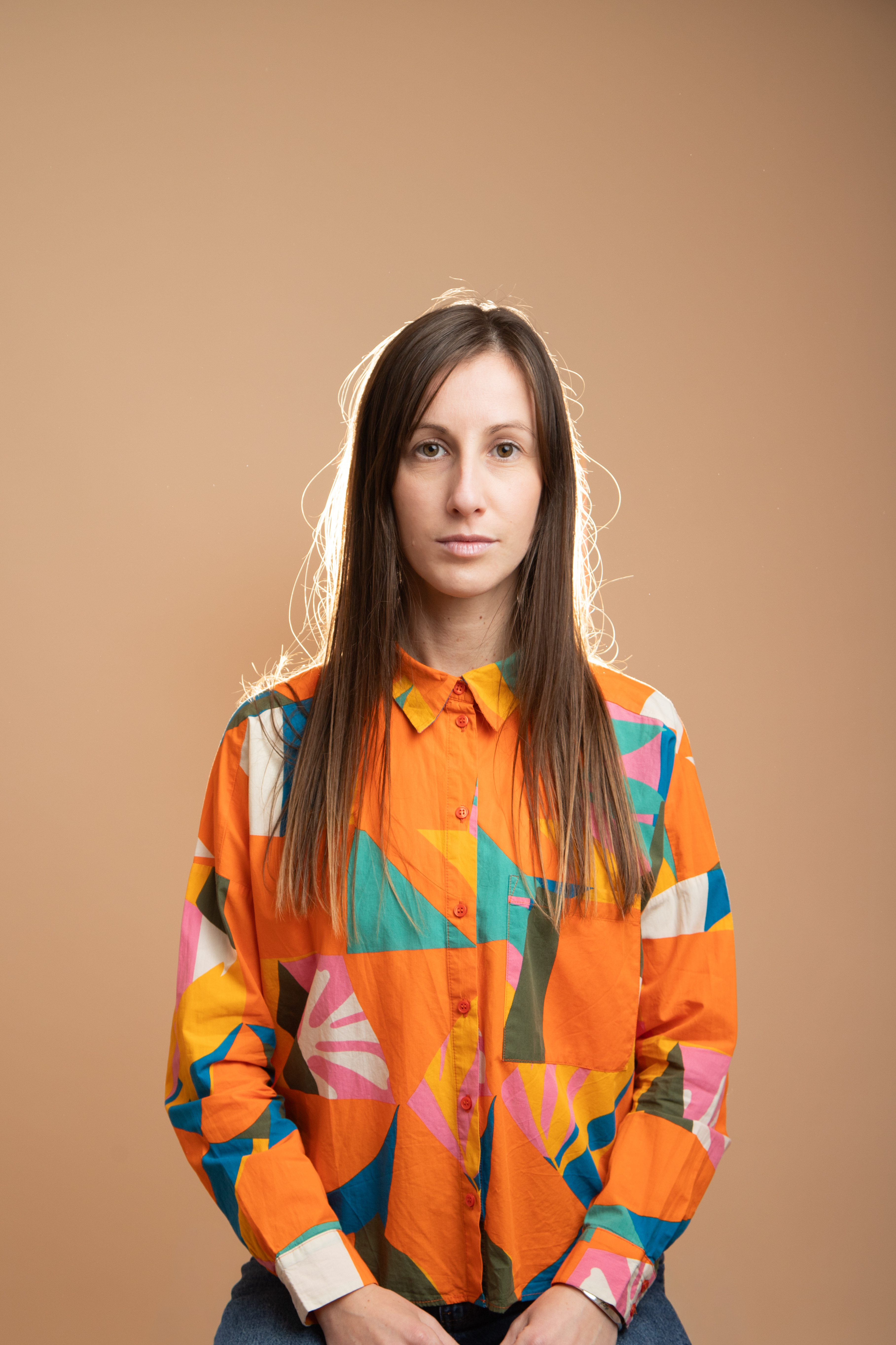 Autoportrait d’Anaïs ROFFI, photographe famille et mariage en Provence. Style années 80, lumière flash, fond orangé, ambiance pop et assumée.